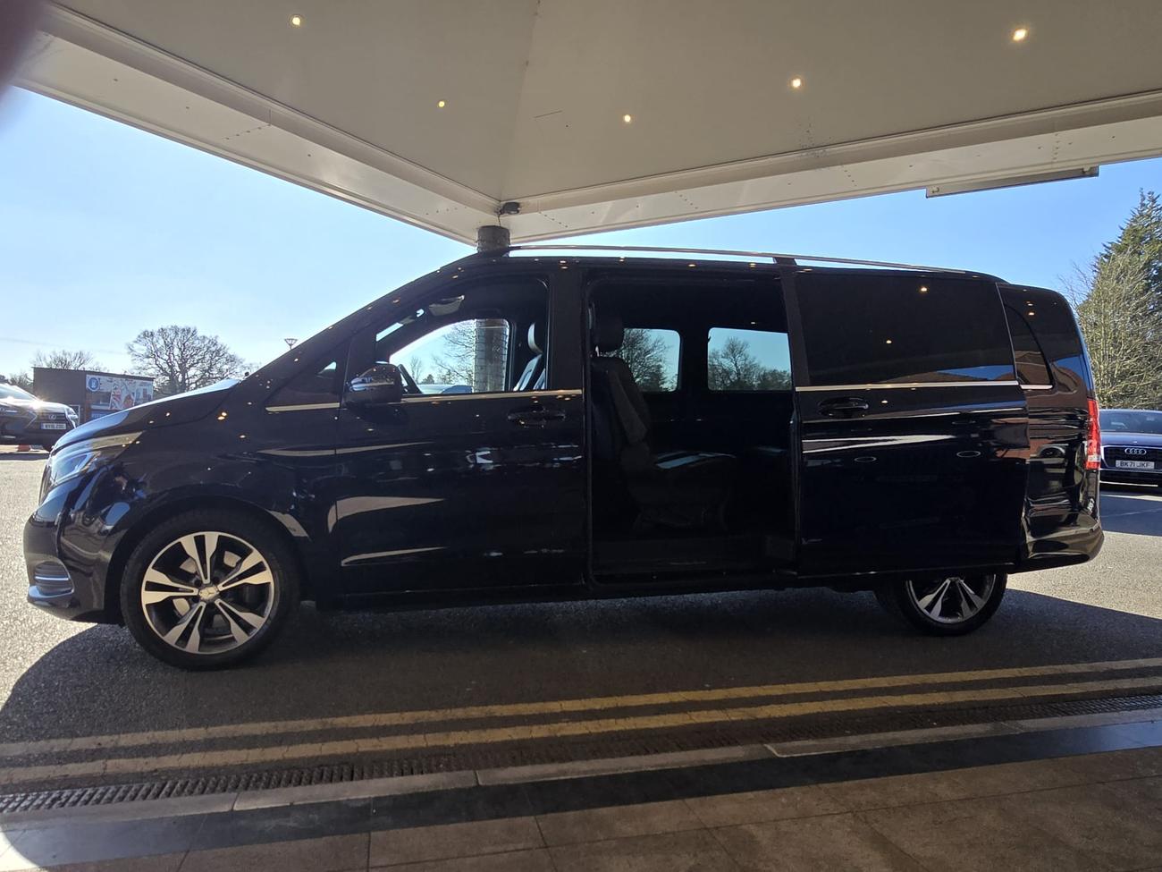 Mercedes V-Class with its side door open at a hotel entrance